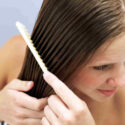 Mujer peinándose el pelo liso con aceite de Argán
